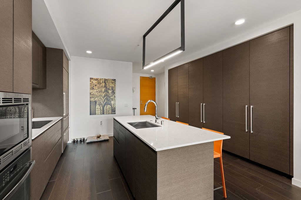 A modern kitchen with a white countertop and brown cabinets.