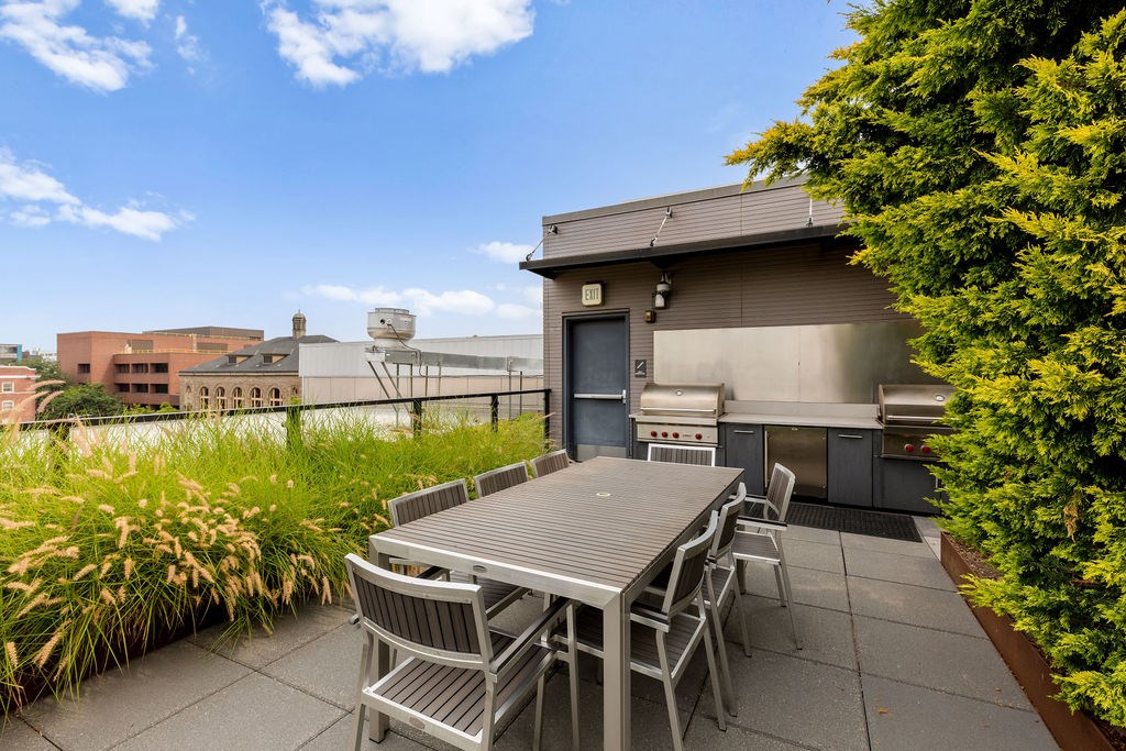 A patio with a table and chairs overlooking a cityscape.