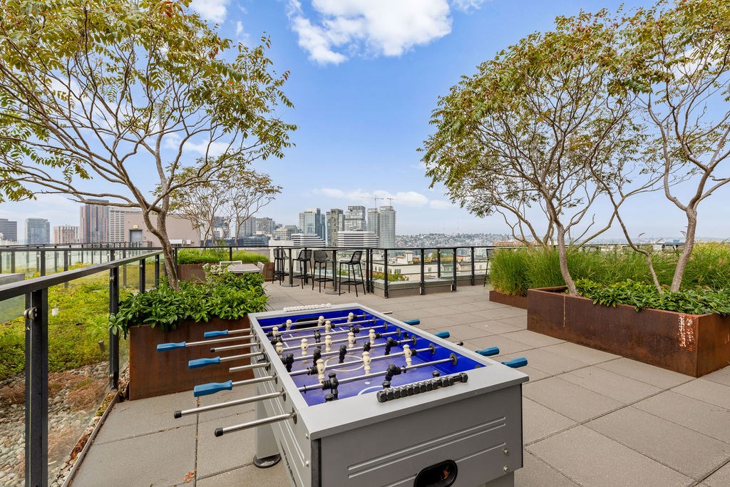 A foosball table is on a patio with a view of the city.