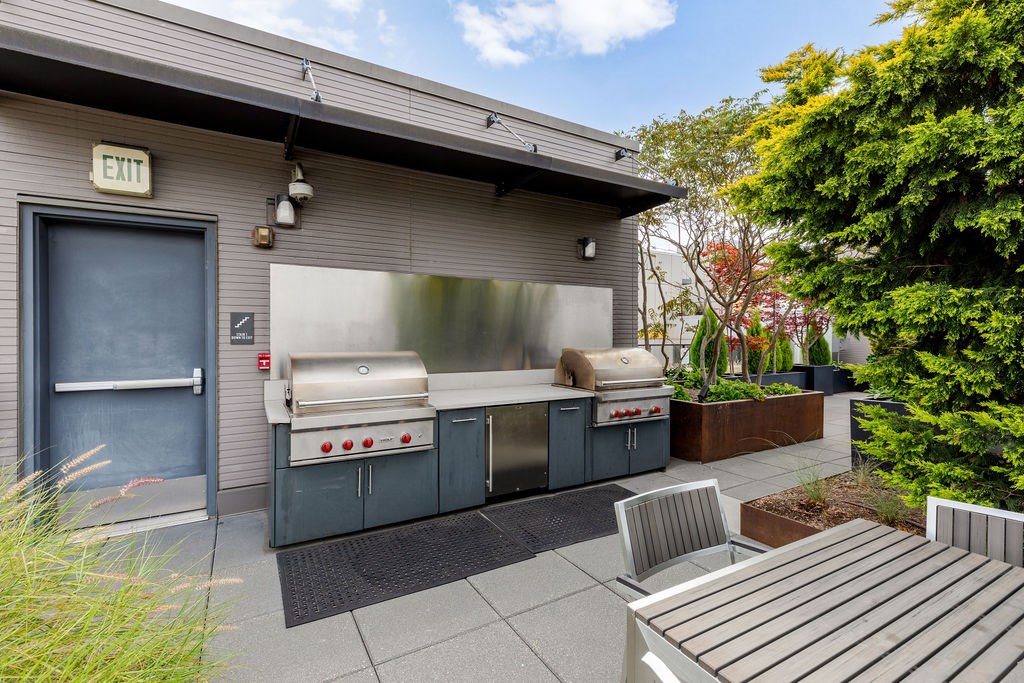 A small outdoor kitchen area with a grill and sink.