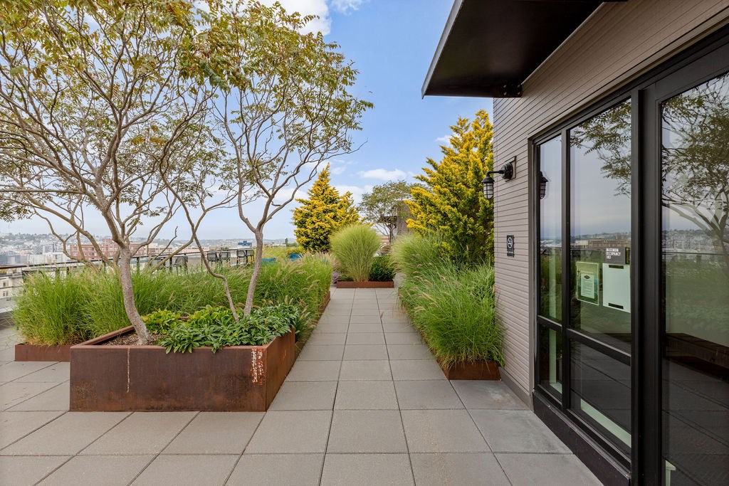 A patio with a view of the water and a variety of plants.