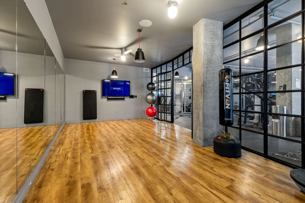 A room with wooden floors and black speaker boxes.