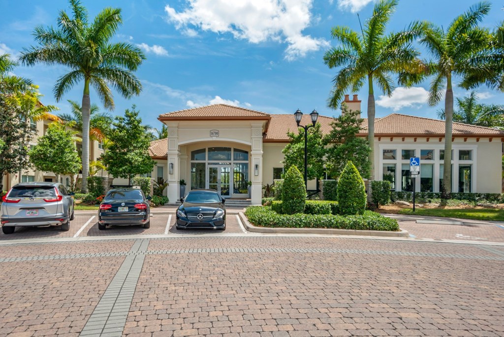 A building with a red roof and a parking lot in front of it.