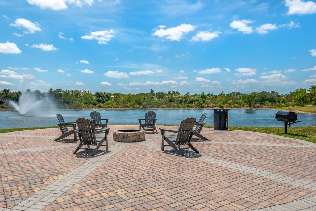 A patio with chairs and a fountain in the background.