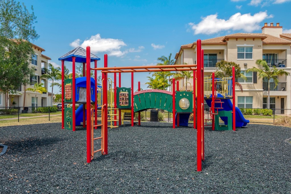 A playground with a red swing set and a blue slide.