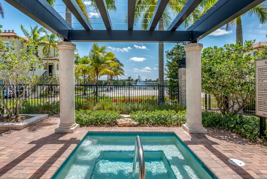A pool surrounded by a black fence and a white pillar.