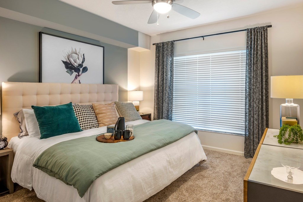 A bedroom with a large bed and a vanity table.