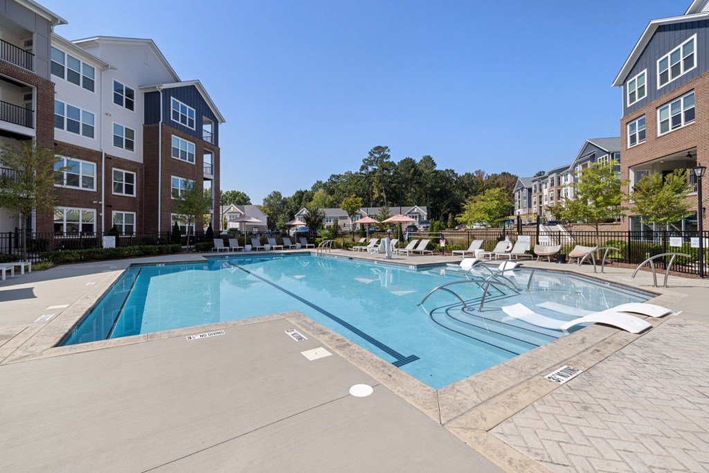 A large swimming pool surrounded by apartment buildings.