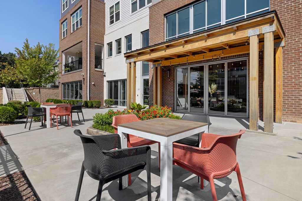 A patio with a table and chairs is in front of a building.