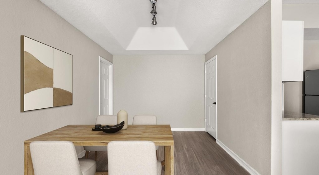 A dining room with a wooden table and white chairs.
