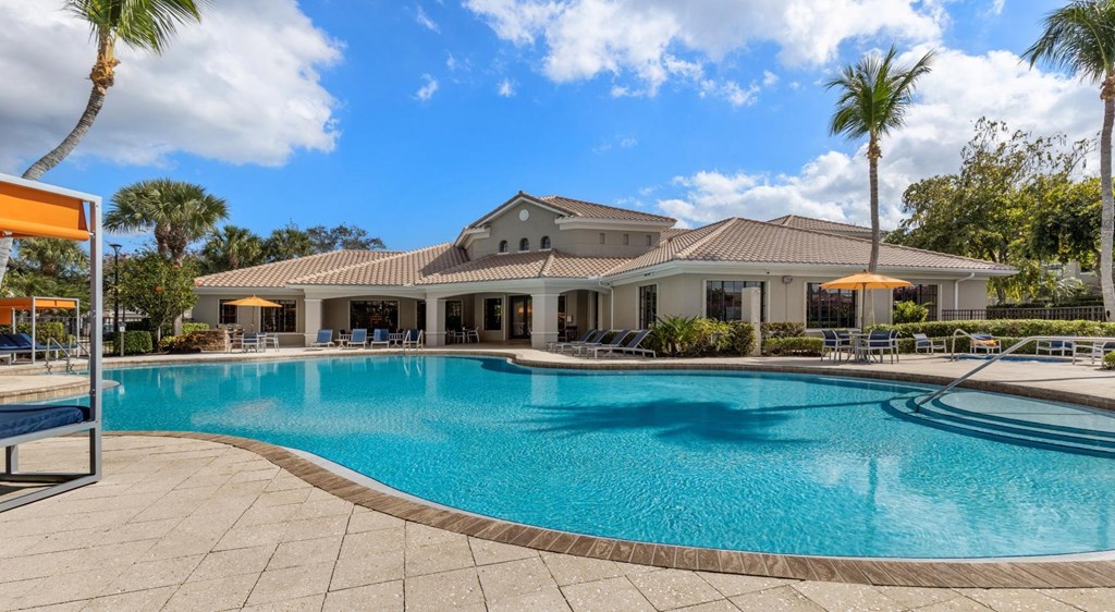 A large house with a pool in front.