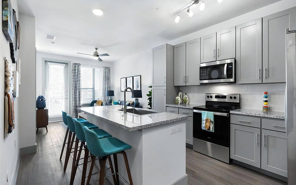 Modern Kitchen with Stainless Steel Appliances and Granite Countertops at Rhythm Apartments
