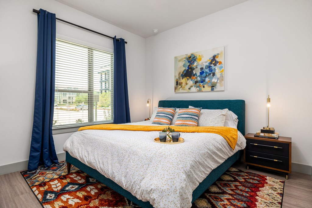 Rhythm bedroom with a large bed and a painting on the wall.