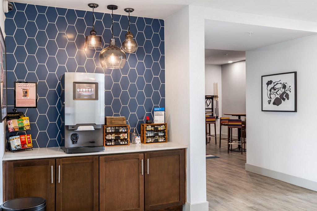 Rhythm Coffee and Tea Bar with A coffee machine on a counter with a blue tile wall behind it.