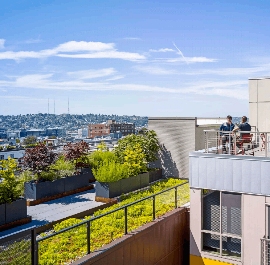 Residents Enjoying Rooftop Balcony Overlooking City Neighborhoods
