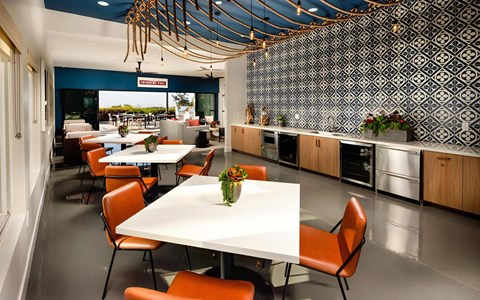 a dining room with tables and chairs and a kitchen