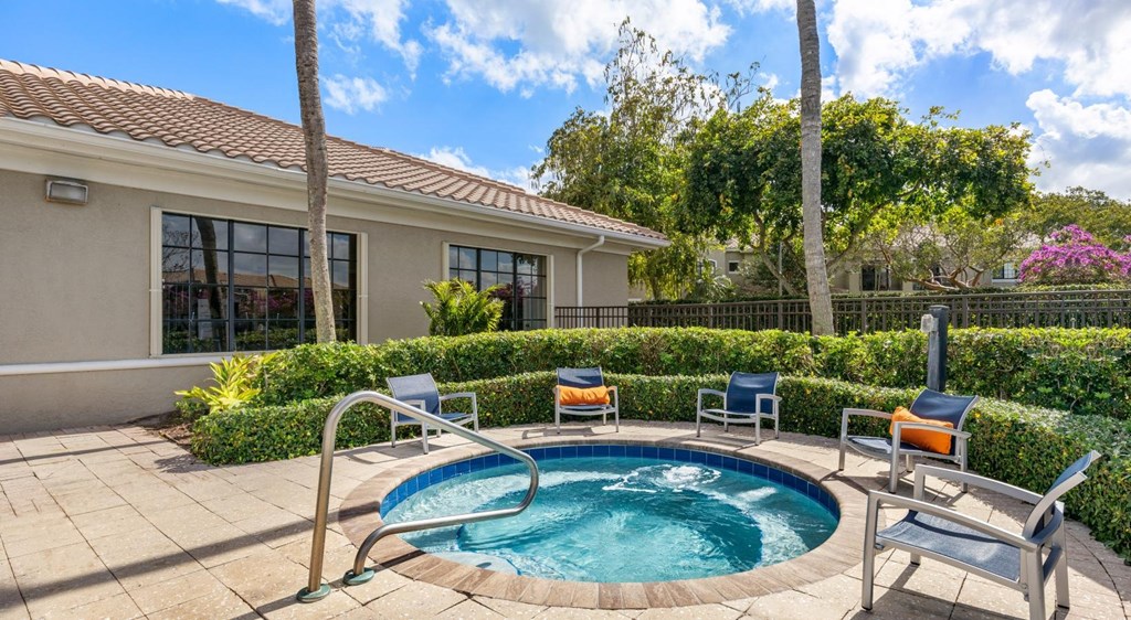 A small pool in a backyard with a house in the background.