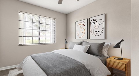 Bedroom with a gray upholstered bed, two framed line drawings, wood nightstands and a wide blinded window beside.