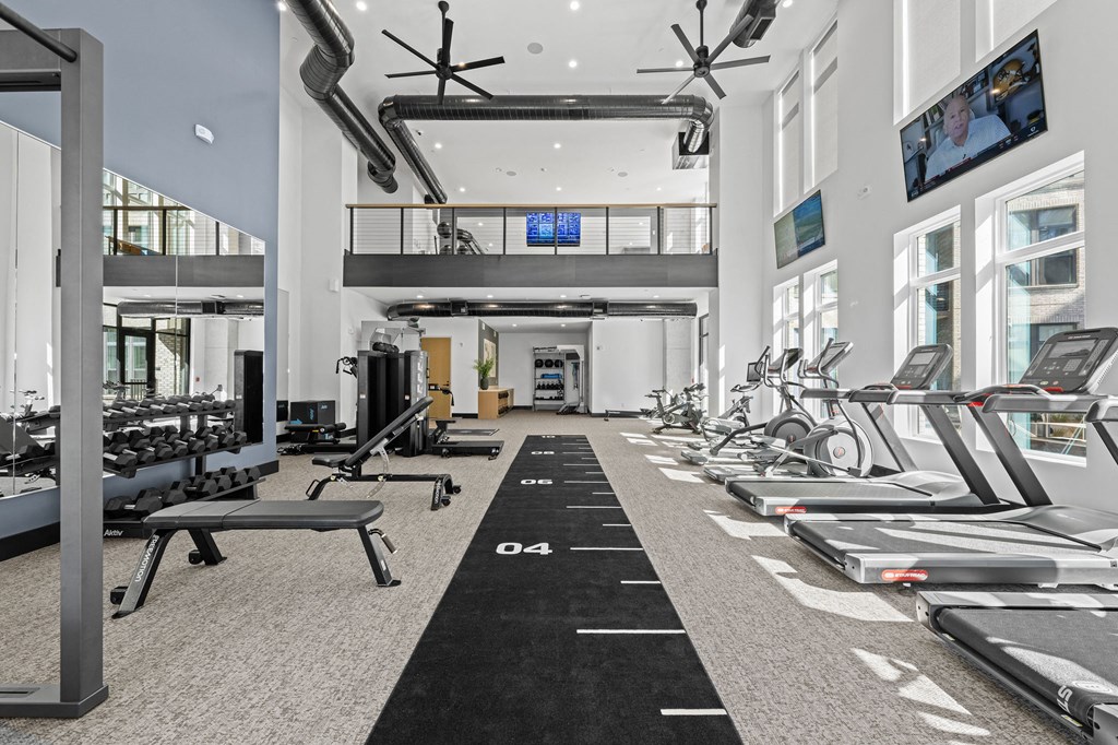 A gym with treadmills, weights, and exercise equipment.