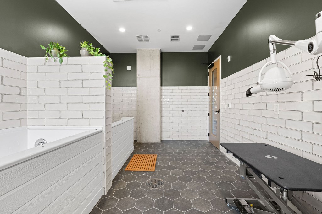 A bathroom with a white bathtub and a black table.