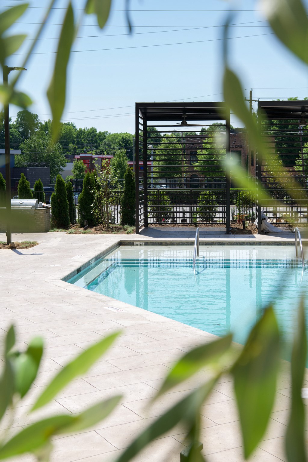 a swimming pool with a fence around it and trees in the background