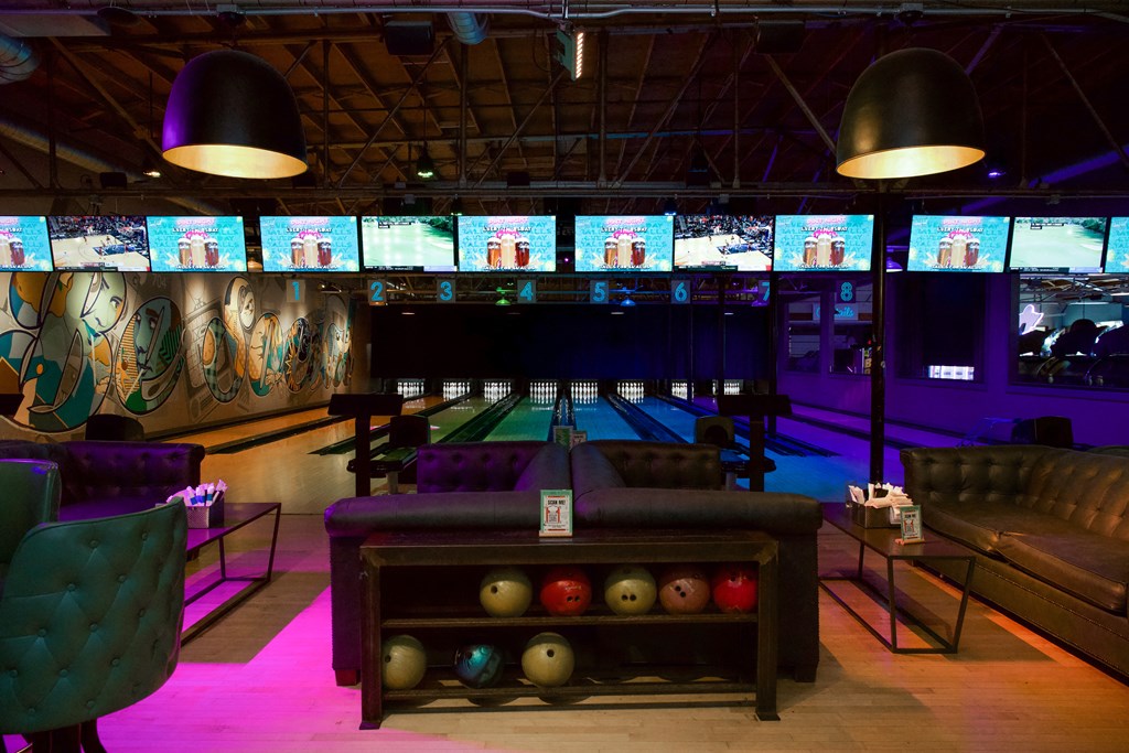 a bowling alley with bowling balls in front of a row of bowling pins