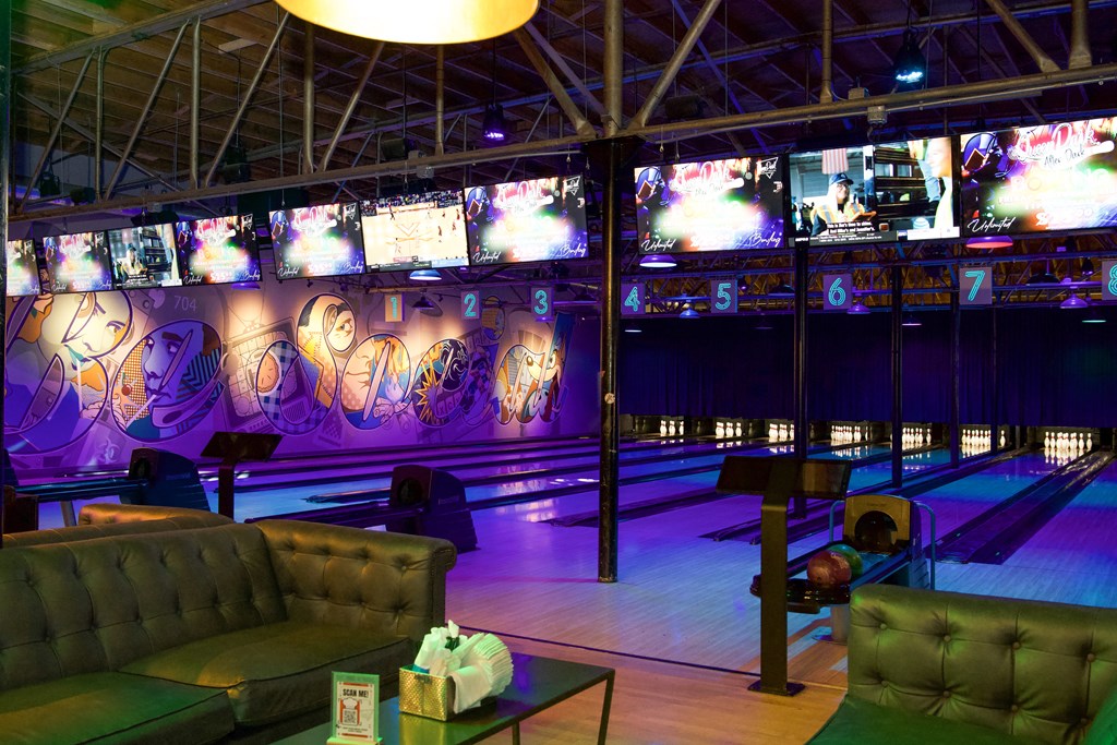 a bowling alley with bowling lanes and couches