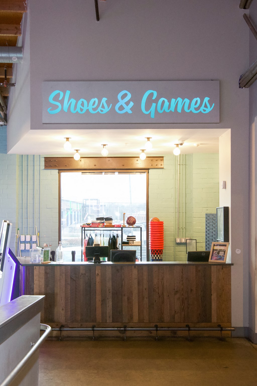 the front desk of shoes  games with a blue neon sign