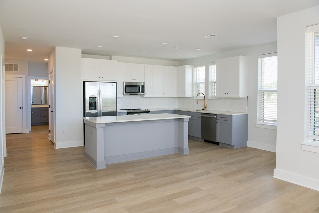 a large kitchen with white cabinets and a large island in the middle