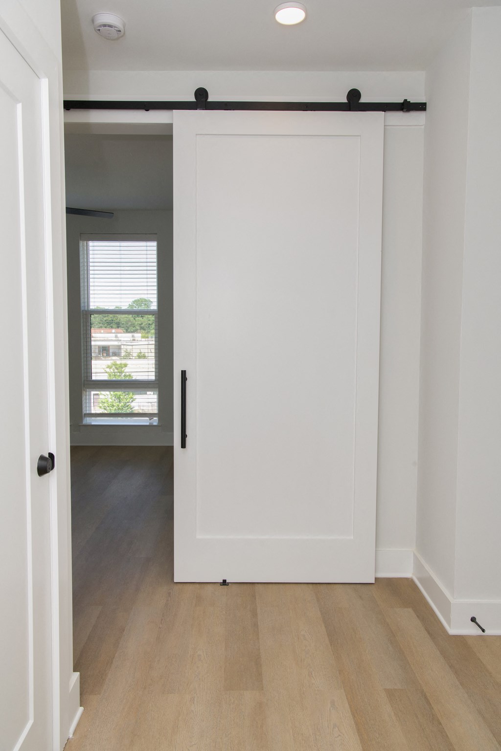 a white sliding door in a room with wood floors