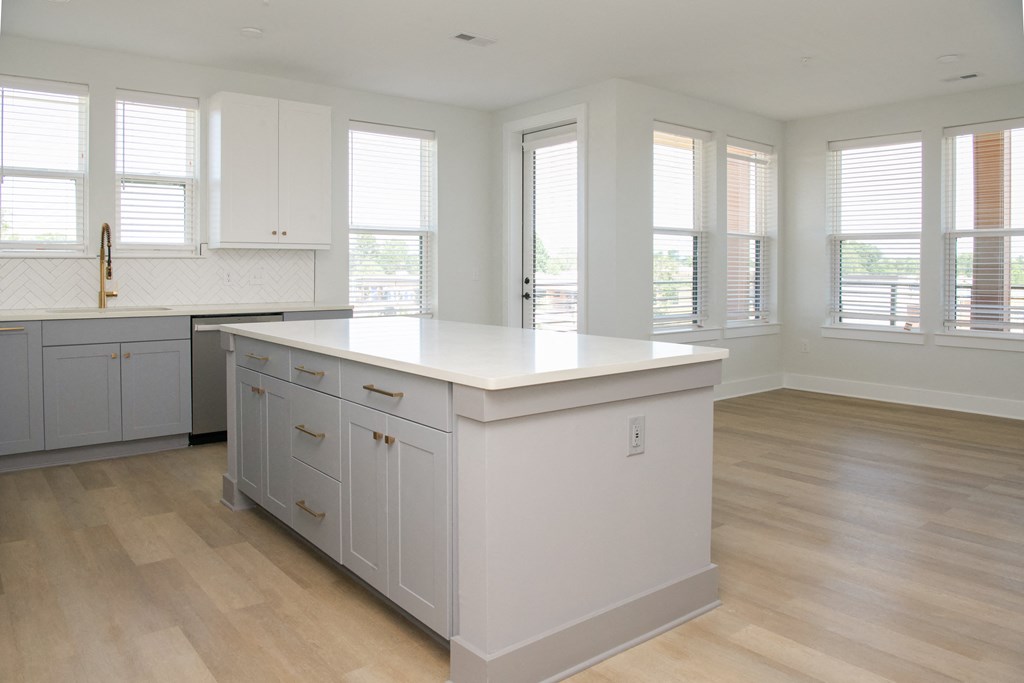a large white kitchen with a large island in the middle