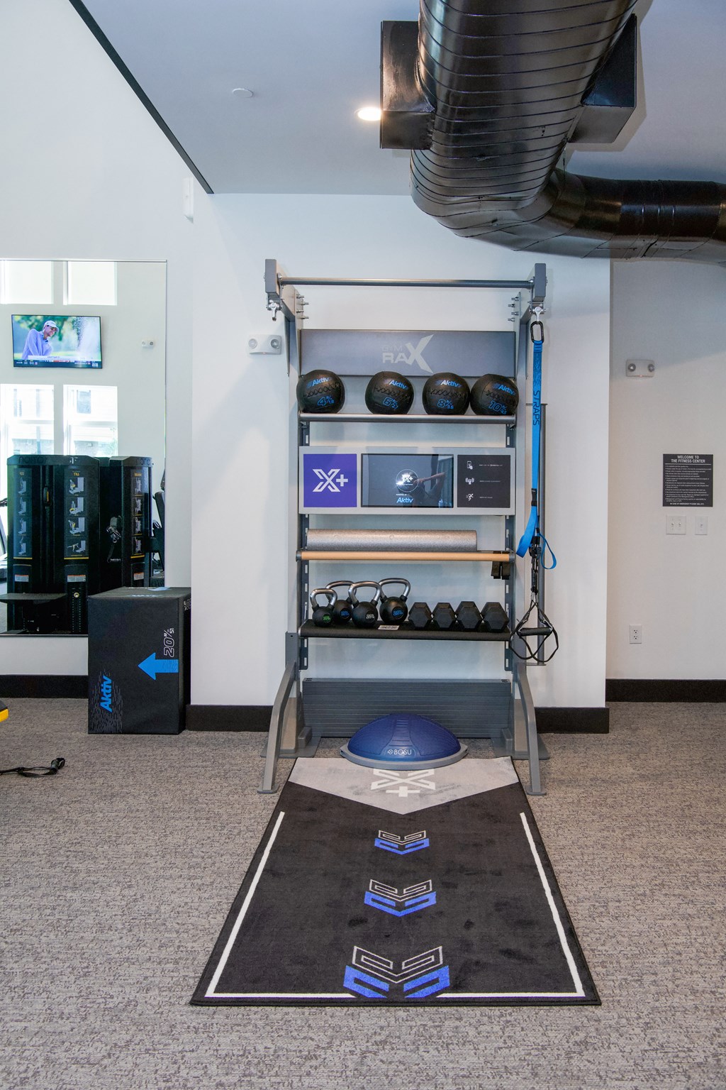 A gym with a black mat and weights.