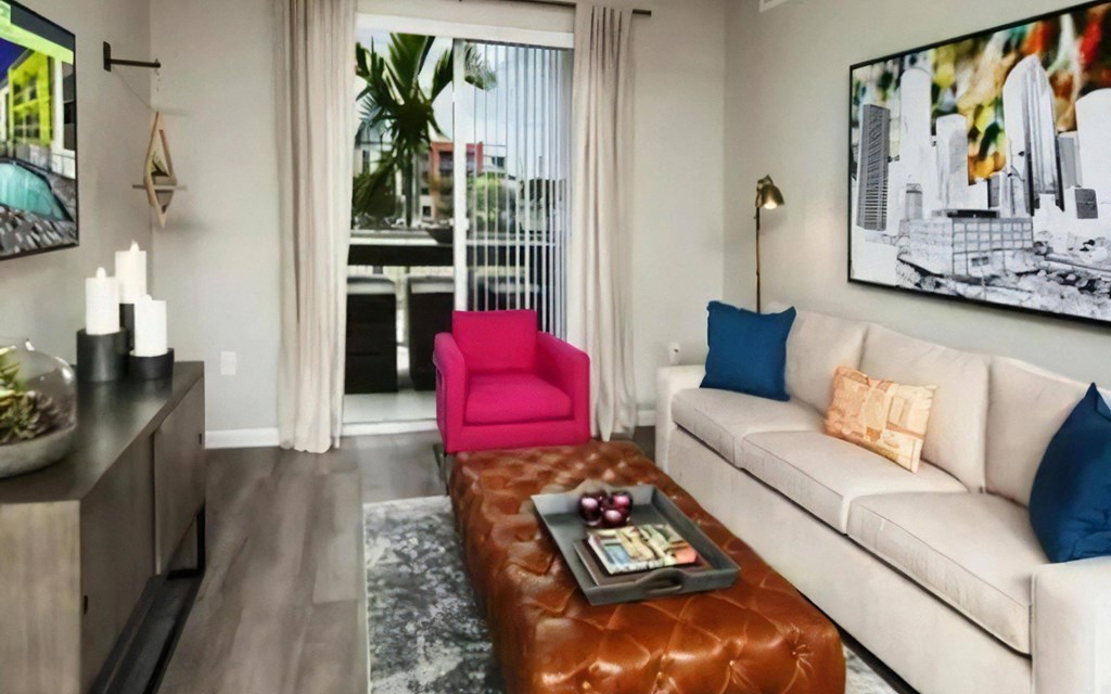 Open Living Room with Sliding Balcony Door, Leather Ottoman, and Framed City Artwork
