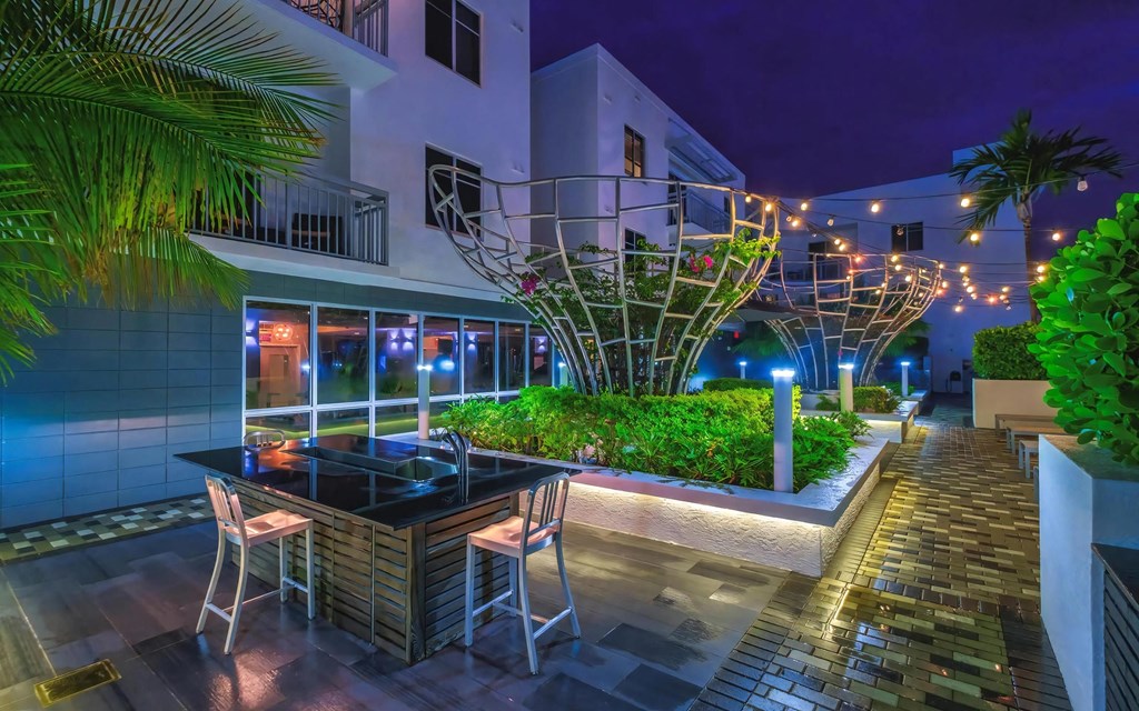 Lit Patio Lounge Featuring Greenery and Sculptural Elements at South of Atlantic