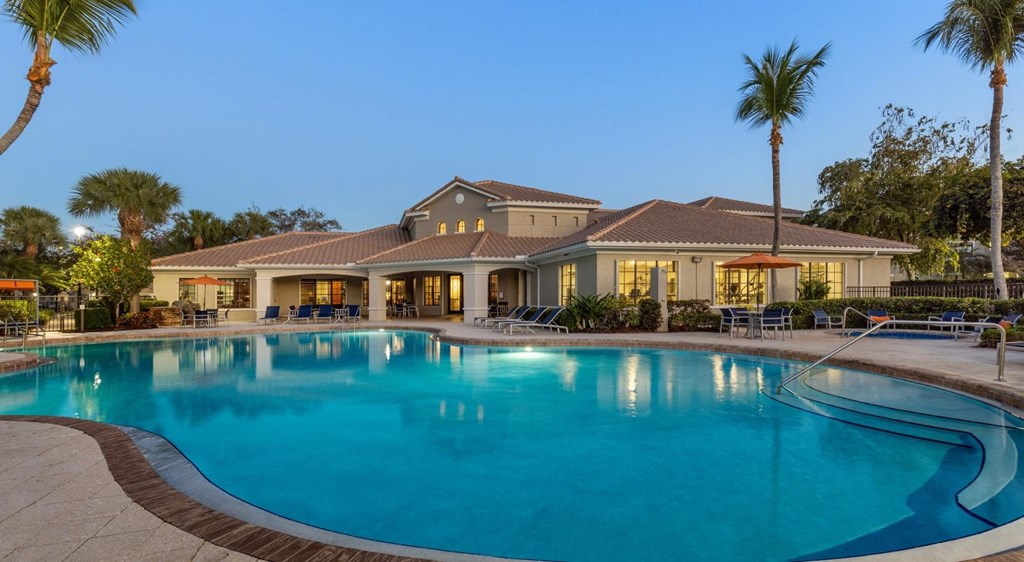 A large house with a pool in front.