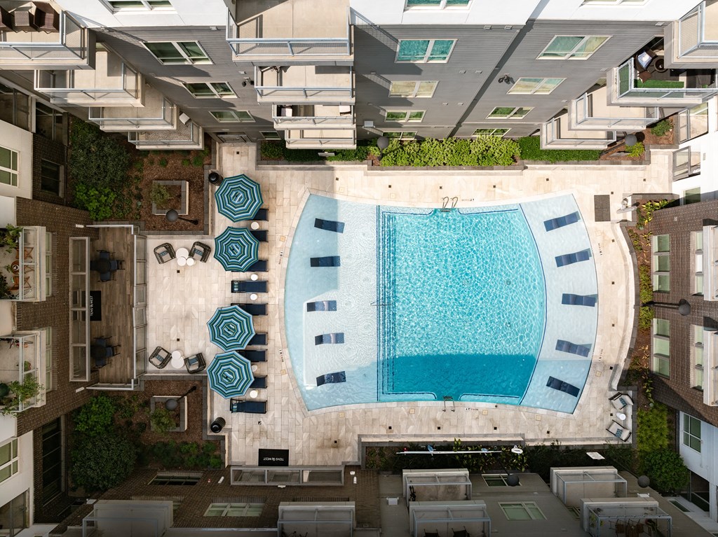 Overhead Look at Apartment Community Pool with Umbrellas and In-Pool Loungers