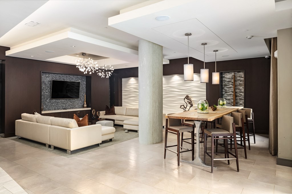 Resident Club Room Featuring TV, Lounge Seating, and Modern Pendant Lighting
