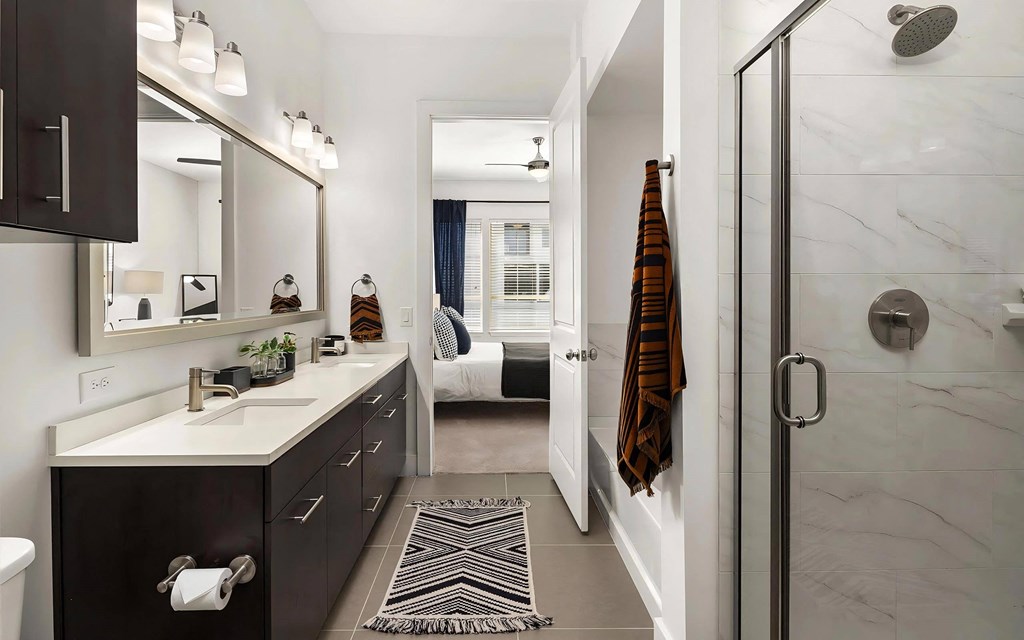 Ensuite Bathroom Featuring Dual Vanities and Glass Walk-In Shower