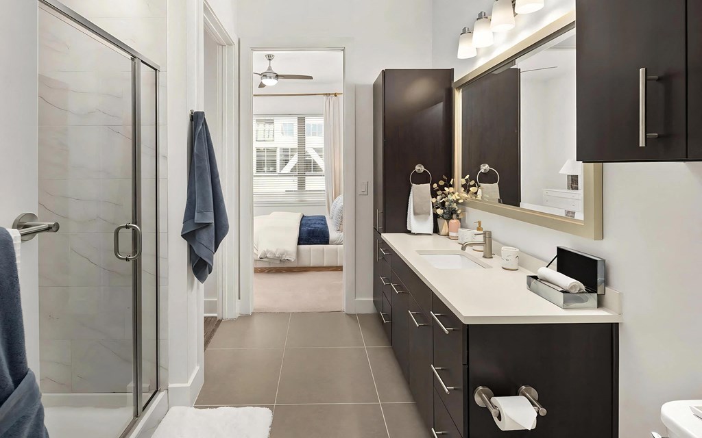 Ensuite Bathroom with Modern Cabinetry, Lighting, and Ample Counter Space