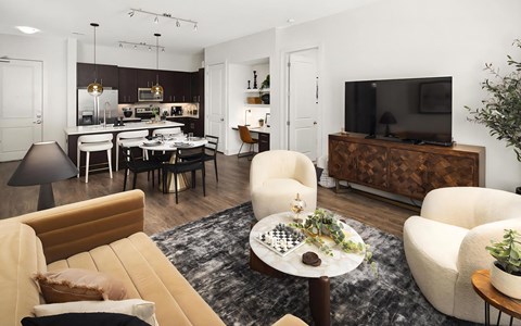 a living room and kitchen with a couch and chairs