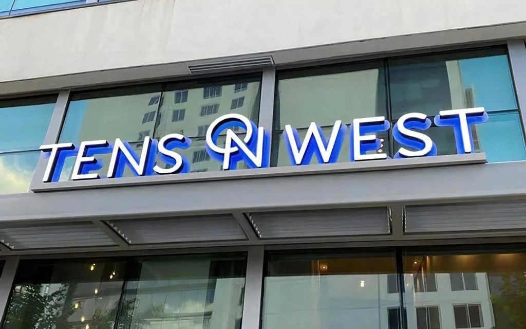 Close-Up of Tens on West Apartment Name on Glass Building Facade