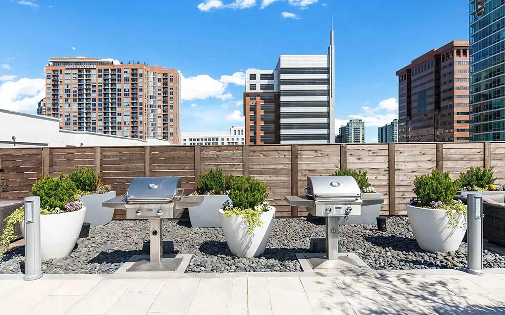 Outdoor Grill Area on Rooftop Deck With Privacy Fence and Seating