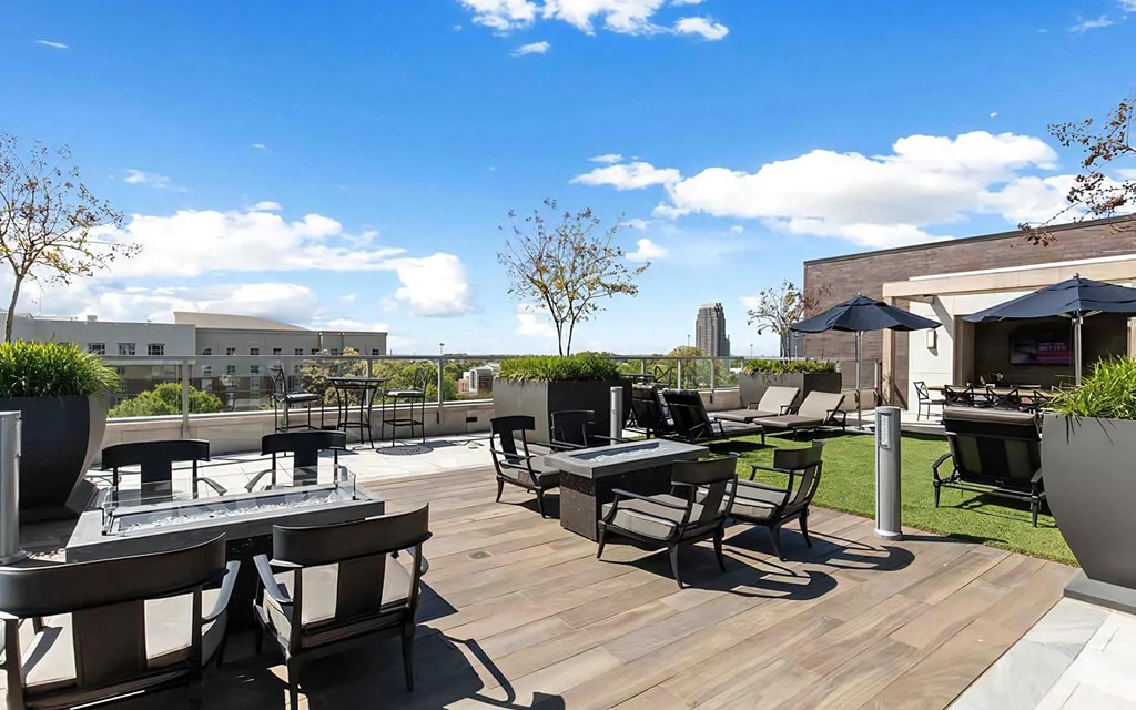 Rooftop Lounge Area With Fire Pits, Seating, and Shade Umbrellas