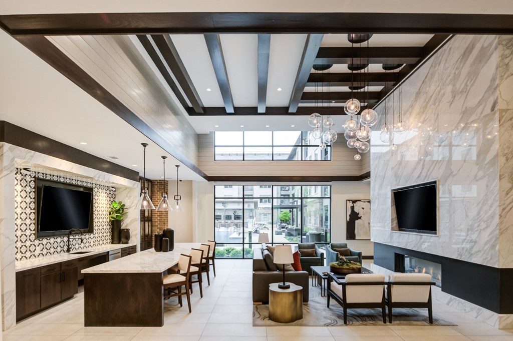 the lobby of a hotel with couches and chairs and a fireplace
