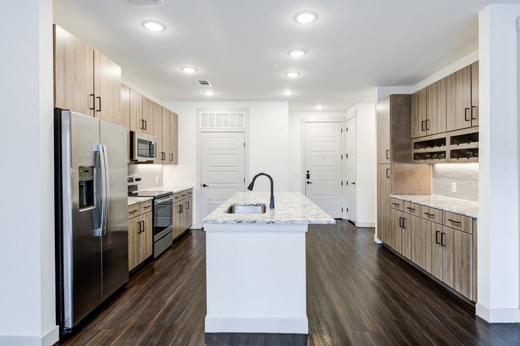 a large kitchen with stainless steel appliances and marble counter tops