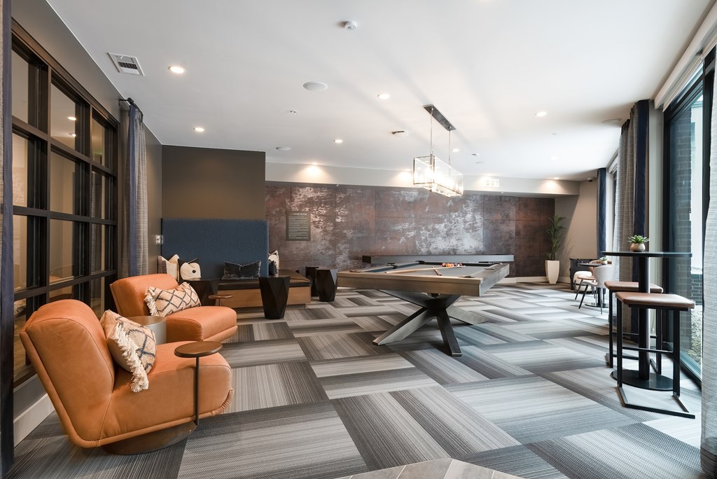 Modern Game Lounge with Pool Table, Casual Seating, and Industrial Accents