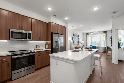 A modern kitchen with wooden cabinets and stainless steel appliances.