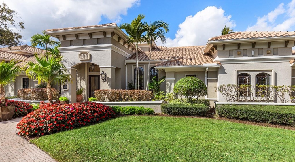 A house with a well-manicured lawn and a clear blue sky above.