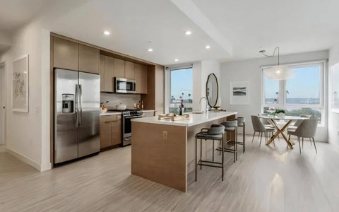 a kitchen with a large island and a table with chairs