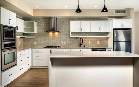 a modern kitchen with white cabinets and stainless steel appliances